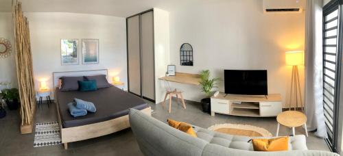 a living room with a bed and a couch at Studio Kooka nui - Private apartment in Papeete