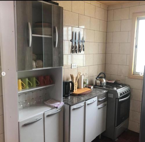 a kitchen with a stove and a counter top at Cabañas Vista Hermosa Radal 7 Tazas in El Torreón