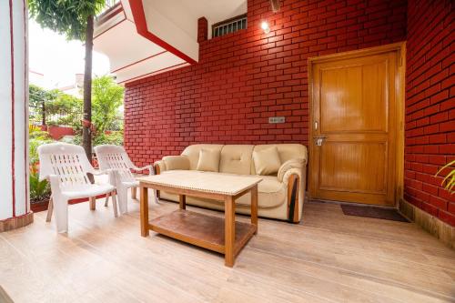 a living room with a couch and two chairs at OYO Home Gautam Homestay in Dehradun