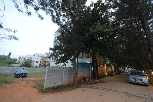 a house with a car parked next to a fence at VOVO HOTELS in Yelahanka