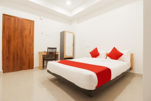 Sakthi Grand في إرود: غرفة نوم بسرير كبير ومخدات حمراء