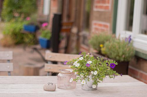 a jar with flowers in it sitting on a table at Landhaus Müden in Faßberg