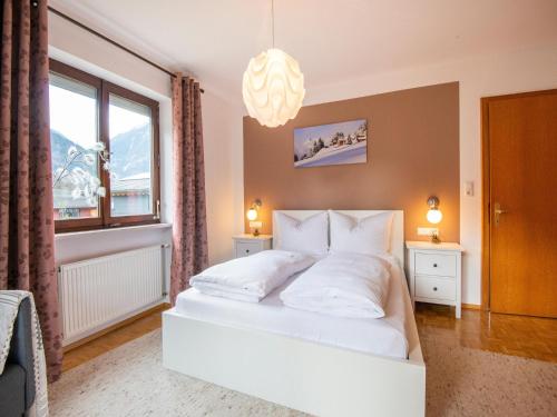 ein Schlafzimmer mit einem weißen Bett und einem Fenster in der Unterkunft Ferienhaus Linde in Bartholomäberg