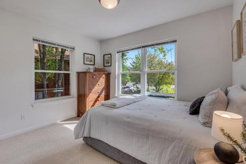 a bedroom with a large bed and two windows at Cozy Home with Sauna in Glenwood Springs in Glenwood Springs