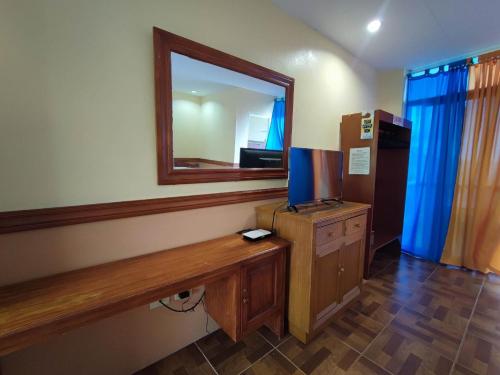 Sea Forest Resort في Sibulan: غرفة بها مرآة وتلفزيون على طاولة