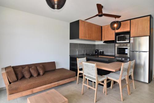 博坎卡諾特的住宿－Résidence UltraMarine，厨房以及带沙发和桌子的用餐室
