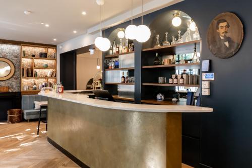 a bar in a restaurant with lights on the wall at Hôtel Léopold - Orso Hotels in Paris