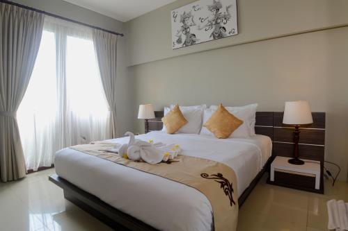 a bedroom with a large bed with two swans on it at Abisha Villa Jimbaran in Jimbaran