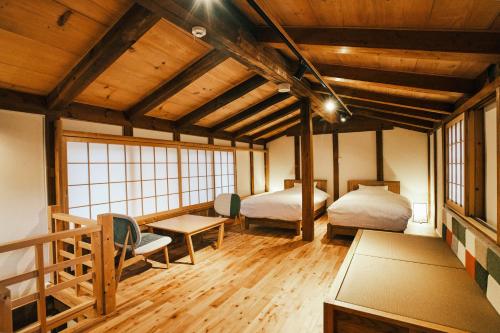a room with two beds and a table in it at SATOYAMA STAY Nino-Machi in Furukawachō