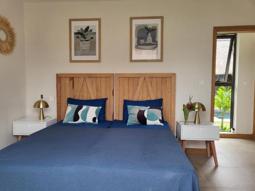 a bedroom with a blue bed with two night stands at Villa de Luxe à Grand Baie avec piscine V12 in Grand Baie