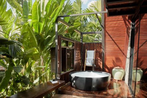 a bath tub in a bathroom with plants at LA COCOTTE VILLA & FARM KHAO YAI in Nong Sarai
