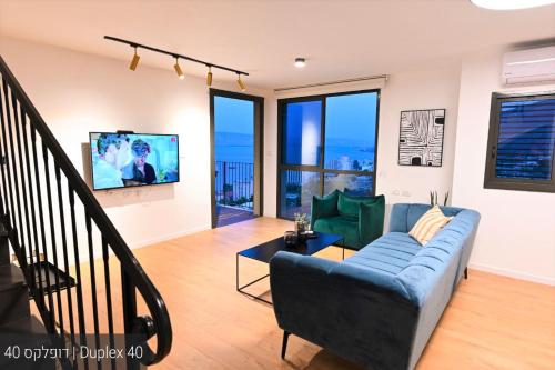 a living room with a couch and a tv at YalaRent La Mera- Suits Hotel with Sea of Galilee views in Tiberias