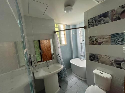 a white bathroom with a sink and a toilet at Xing Yu Inn in Eluan