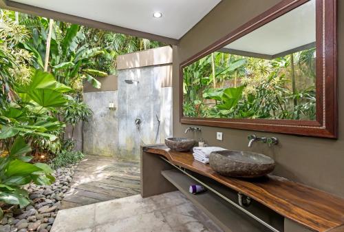 a bathroom with two sinks and a mirror at Villa Yoga in Seminyak