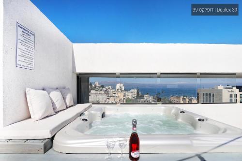 a bath tub in a room with a window at YalaRent La Mera- Suits Hotel with Sea of Galilee views in Tiberias