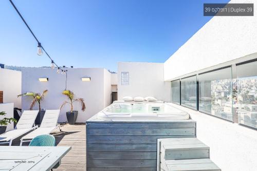a hot tub on the balcony of a house at YalaRent La Mera- Suits Hotel with Sea of Galilee views in Tiberias