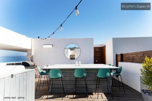 a table and chairs on a balcony with a mirror at YalaRent La Mera- Suits Hotel with Sea of Galilee views in Tiberias