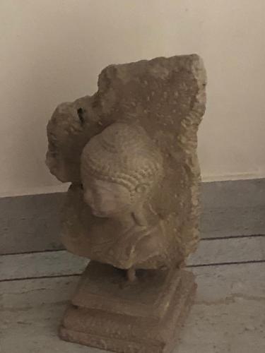 a statue sitting on a stand next to a wall at The Neem in New Delhi