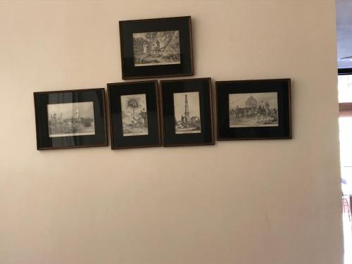 a group of framed photographs on a wall at The Neem in New Delhi