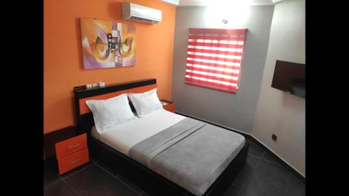 a small bedroom with a bed and a window at Standard Double Bed in Royal Blue Guest House and Bar in Lomé