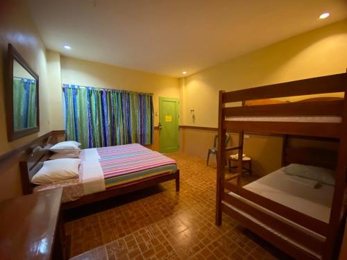Sea Forest Resort في Sibulan: غرفة نوم بسريرين بطابقين وباب أخضر