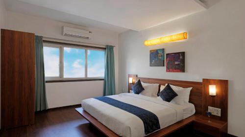 Hotel Ekaa Keys By Rivido - Hosur Main Road, Kudlu Gate في بانغالور: غرفة نوم بسرير كبير ونافذة