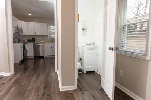 a kitchen with white cabinets and a wooden floor at Newly renovated home less than a mile from downtown Roanoke in Roanoke