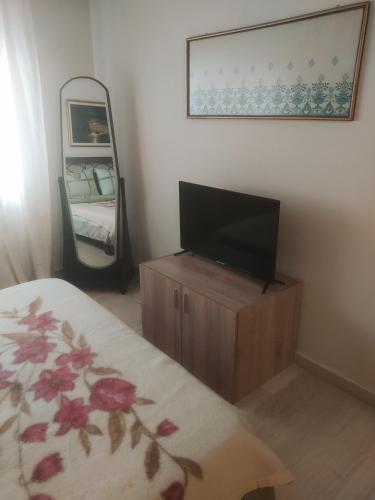 a bedroom with a tv on a dresser and a mirror at MARIOS HOUSE 1 in Xanthi