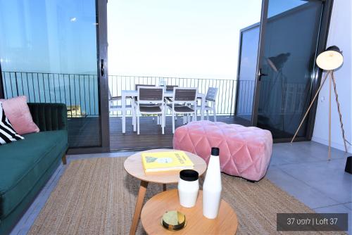 a living room with a couch and a table at YalaRent La Mera- Suits Hotel with Sea of Galilee views in Tiberias
