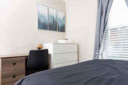 1 dormitorio con cama, escritorio y silla en Newly renovated home less than a mile from downtown Roanoke en Roanoke