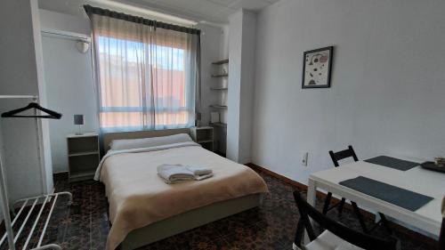 a bedroom with a bed and a table and a window at Pensión Benavente AP-7 3min coche Playa 5 min Self check-in 24h in Moncófar