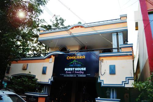 um edifício com um sinal em frente em Omkara - The Fives Guest house em Tiruvannamalai