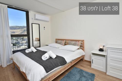 a bedroom with a bed with two towels on it at YalaRent La Mera- Suits Hotel with Sea of Galilee views in Tiberias