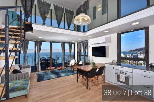 a large living room with a staircase and a living room with a view at YalaRent La Mera- Suits Hotel with Sea of Galilee views in Tiberias