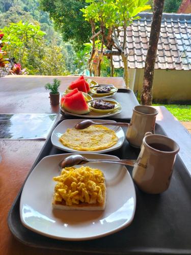 a tray with plates of food on a table at Friendly Homestay Lemukih in Singaraja