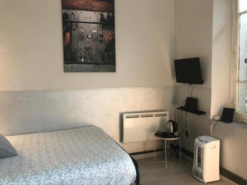 - une chambre avec un lit et une télévision dans l'établissement Maison d'Hôtes La Bastide Bleue, à Marseille