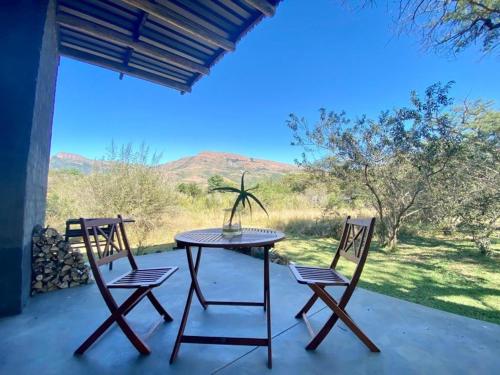 a table and two chairs on a patio with a view at Crocodile Sands River Lodge in Nelspruit