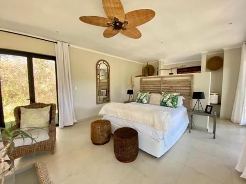 - une chambre avec un lit et un ventilateur de plafond dans l'établissement Crocodile Sands River Lodge, à Nelspruit