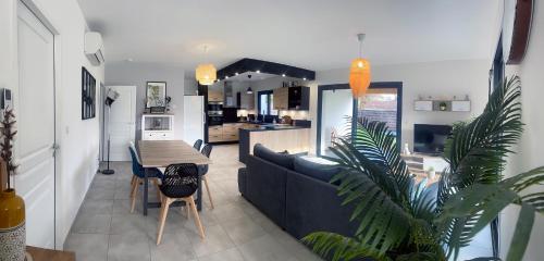 ein Wohnzimmer mit einem Sofa und einem Tisch in der Unterkunft La Villa Morey in Casteljaloux