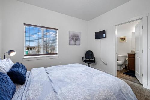 - une chambre blanche avec un lit et une salle de bains dans l'établissement Village Townhouse 2, à Boise