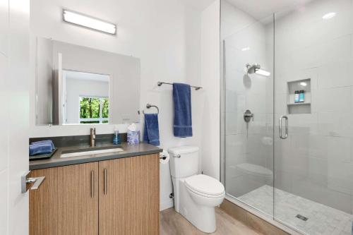 uma casa de banho com um WC e uma cabina de duche em vidro. em Surf Park Place em Garden City