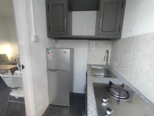 a small kitchen with a sink and a refrigerator at The Perfect Getaway in Grand Baie