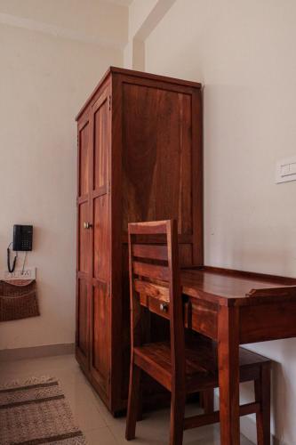 a wooden cabinet and a wooden desk and a wooden chair at Chillout - A Boutique Hotel & Rooftop Restaurant Jaipur in Jaipur