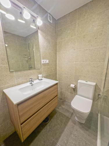 a bathroom with a sink and a toilet and a mirror at Zahara almadraba playa Atlanterra in Zahara de los Atunes