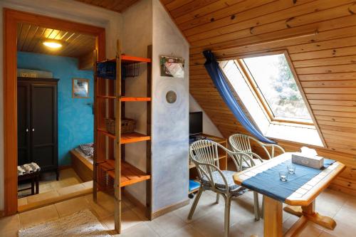 Zimmer mit einem Tisch, Stühlen und einem Fenster in der Unterkunft Chalupa v Meziluzi in Meziluží