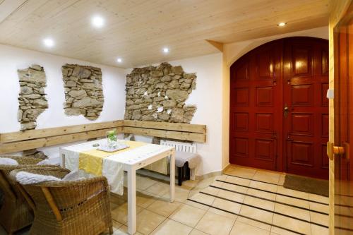 a dining room with a table and a red door at Chalupa v Meziluzi in Meziluží