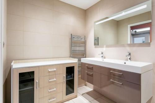 a bathroom with two sinks and a mirror at Appartement T4 Centre Ville Séte tout confort 3 chambres in Sète
