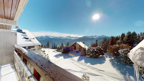 Aussicht vom Balkon eines Hauses im Schnee in der Unterkunft Lovely apartment with a view - accessible by skis in Crans-Montana