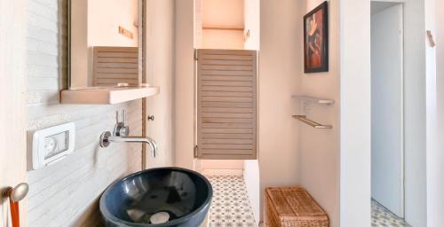 a bathroom with a black sink and a toilet at BnBIsrael apartments - Daniel Royal in Tel Aviv