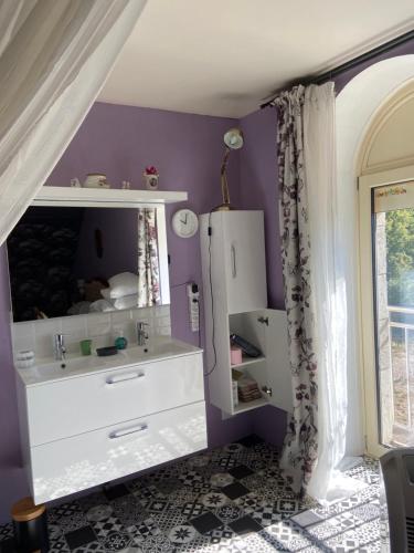 un bagno con un mobile lavabo bianco e pareti viola di Villa Christine Chambre Rose a Marchenoir